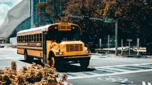 Dzeltens skolas autobuss brauc pa ielu 1. septembra rītā pilsētas vidē.