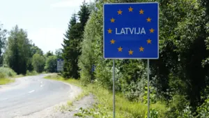 Latvijas valsts robežas zīme uz ceļa, kas ved uz vēlēšanu norises vietām.