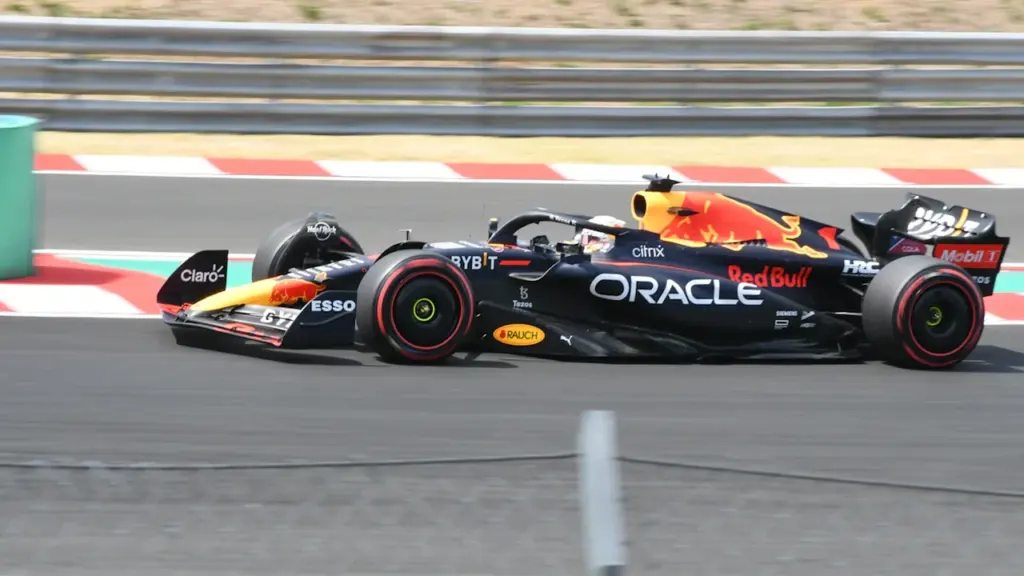 Formula 1 Red Bull sacīkšu auto ātrumā veic pagriezienu sacīkšu trasē vasaras dienā