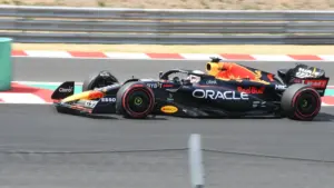 Formula 1 Red Bull sacīkšu auto ātrumā veic pagriezienu sacīkšu trasē vasaras dienā