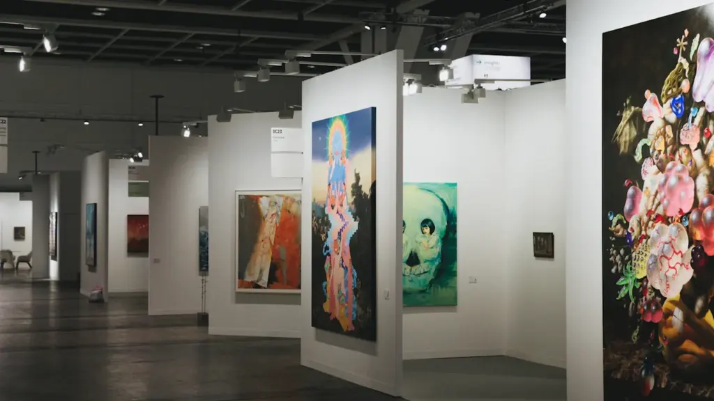 Mākslas galerijas telpas ar gleznām pie baltām sienām izstādes norises vietā.