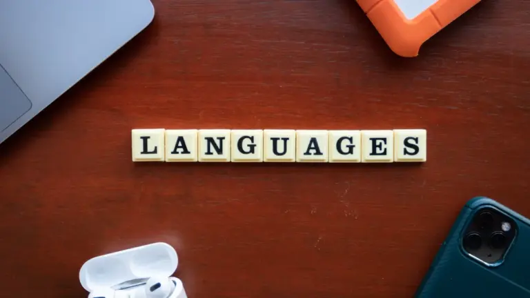 Koka klucītis ar uzrakstu 'languages' uz koka virsmas, simbolizējot valodu daudzveidību.