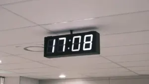 Digitālais pulkstenis pie griestiem, kas atgādina par laika maiņu ceļojumu laikā.